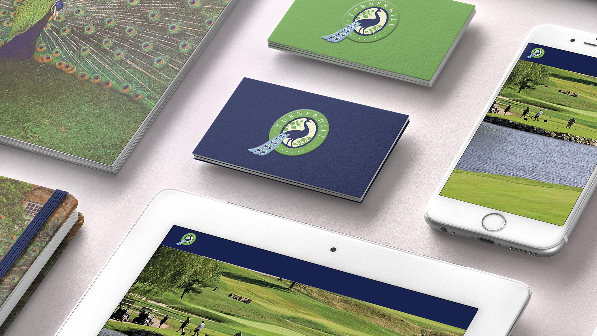 close up of turner hill business cards and iPad with peacock logo