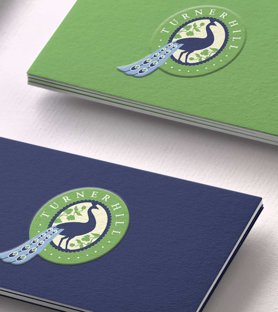 Extreme closeup of turner hill blue and green business cards with peacock logo