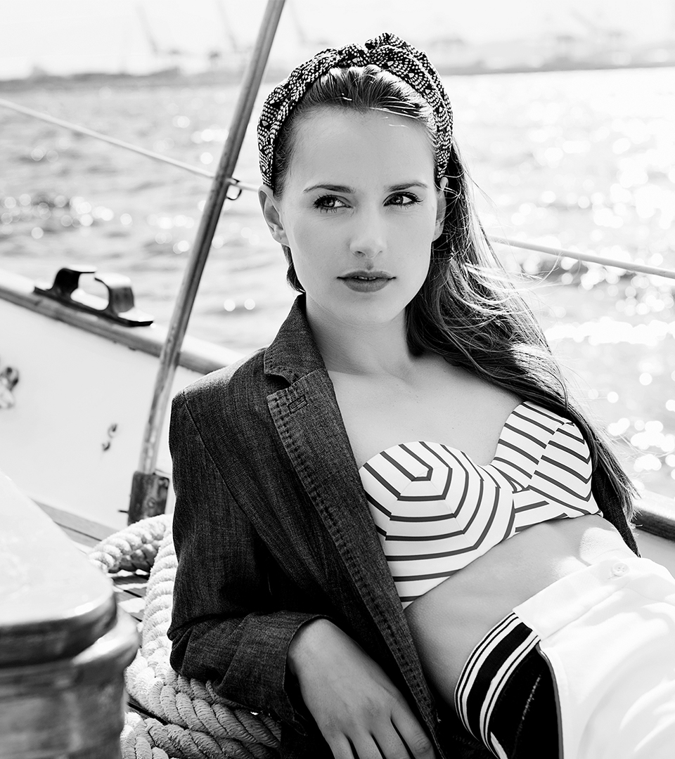 50 liberty girl sitting on sailboat with striped bathing suit