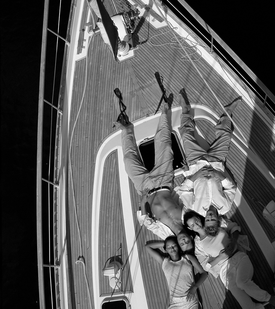 overhead view of young people laying on deck of yacht