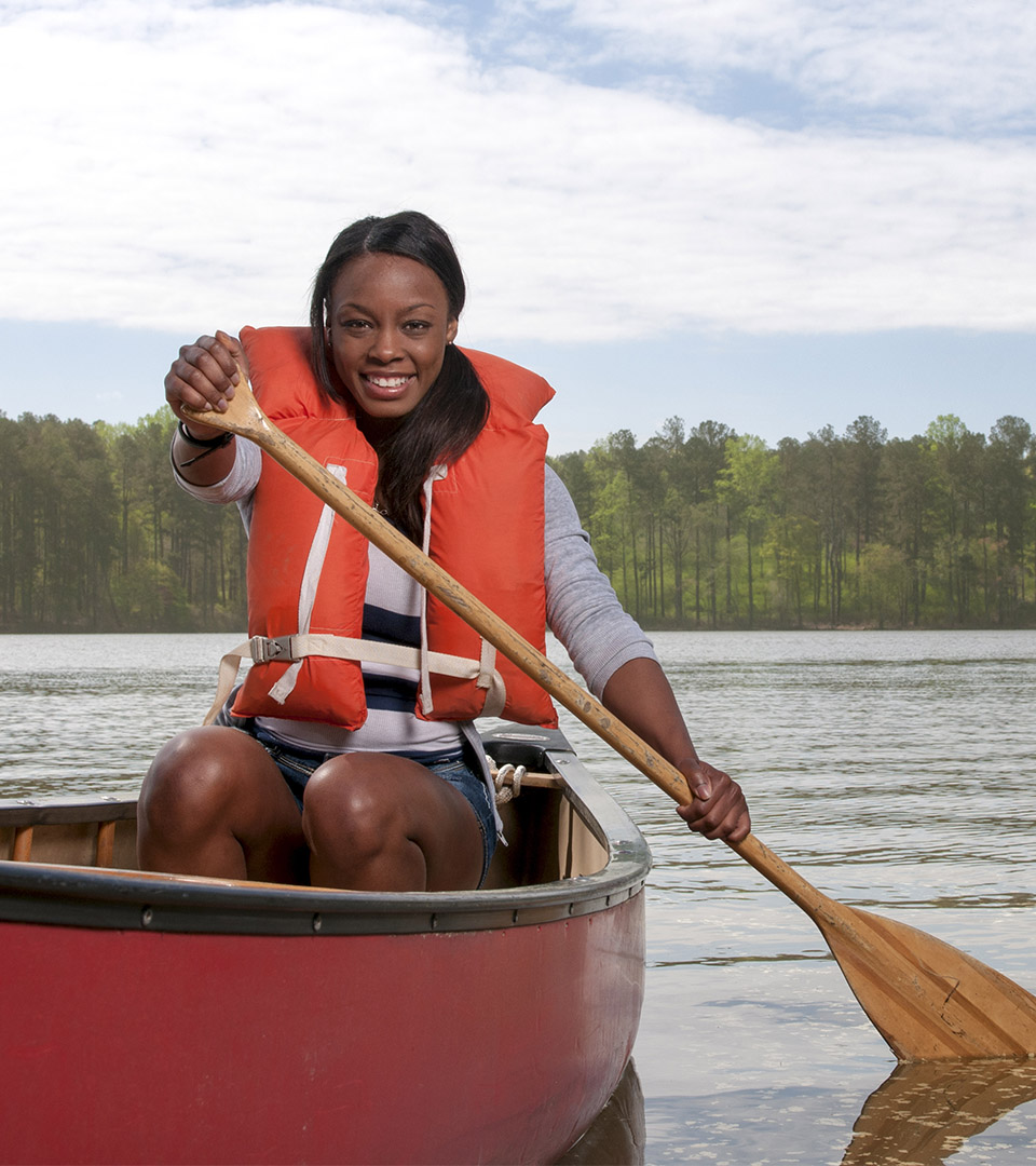 re150 young african american woman in red canoe with paddle