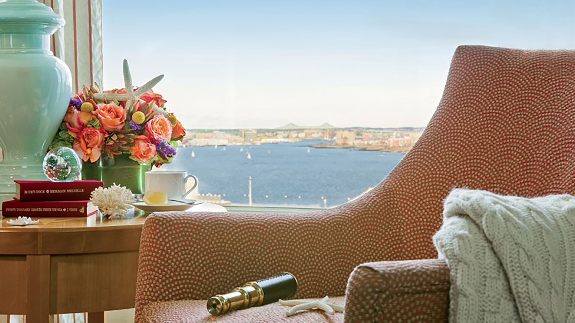 seaport hotel chair by window with lamp and books