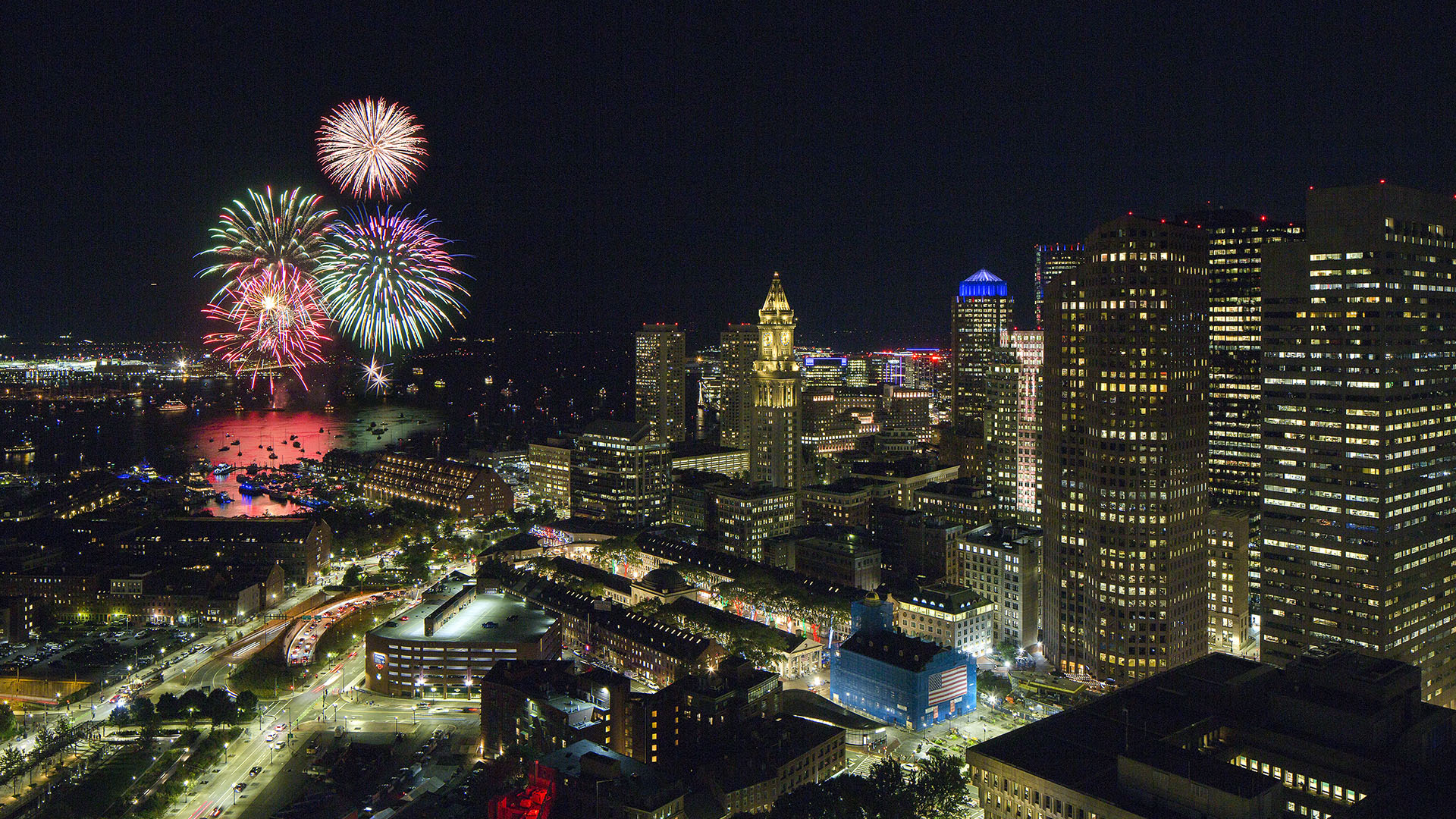 view from sudbury to fireworks in boston harbor at night with city below