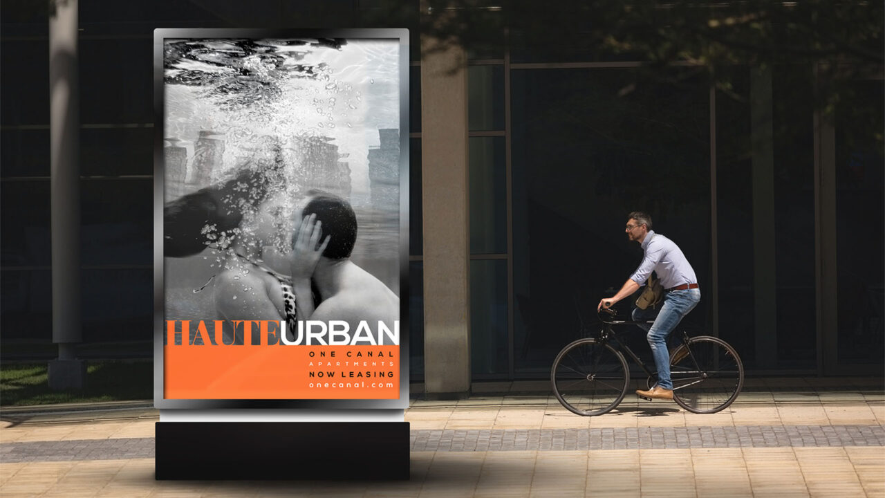 one canal-haute urban in orange and kissing couple underwater with man passing by on bicycle