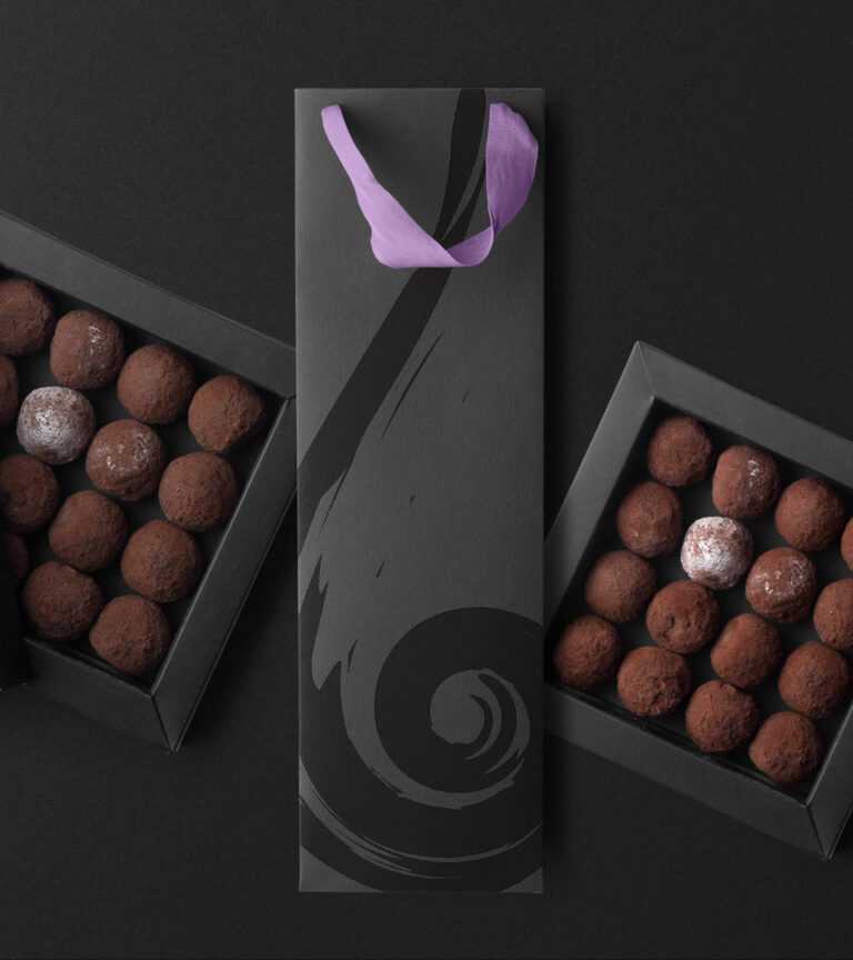 bermans fine wines and spirits dark bag with candy in boxes on dark background by Boston graphic design studio.