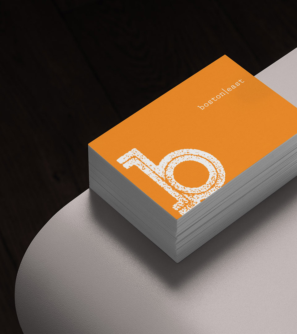 boston east business card on gray table vertical