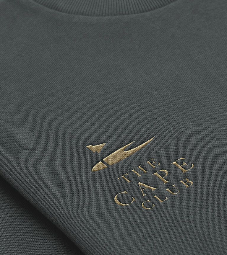 Print collateral for The Cape Club showcasing the unified residential and golf community branding.