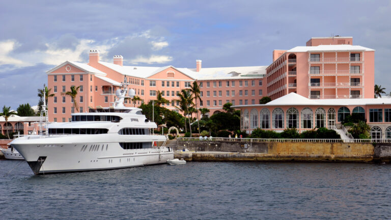 fairmont hamilton princess hotel from the water with yacht in front