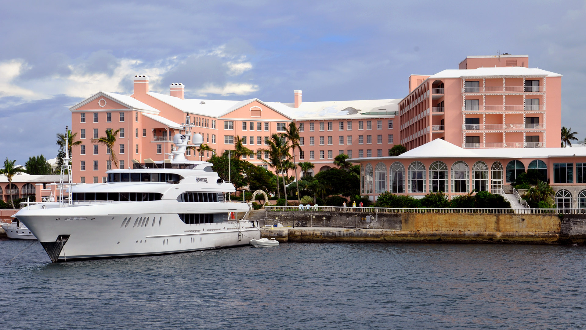 fairmont hamilton princess hotel from the water with yacht in front