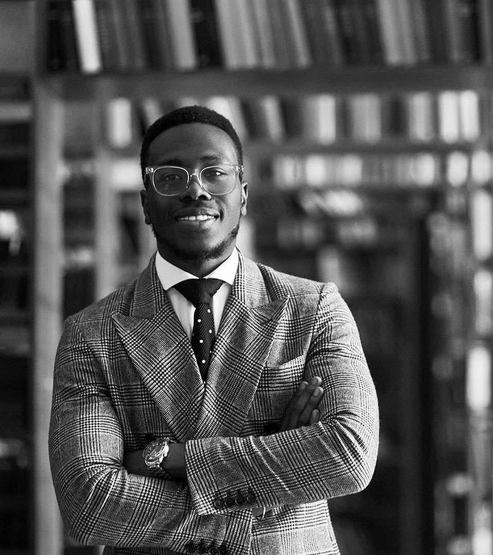 grant mccarthy gagnon african american man with bookcase in background vertical