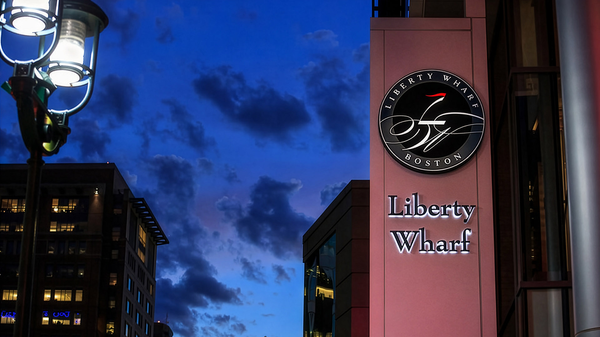 liberty wharf sign on building at night