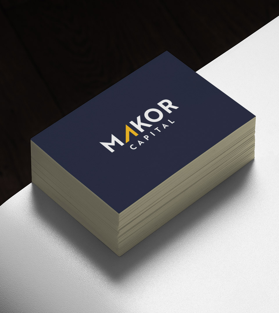 makor capital navy blue business card on white table vertical