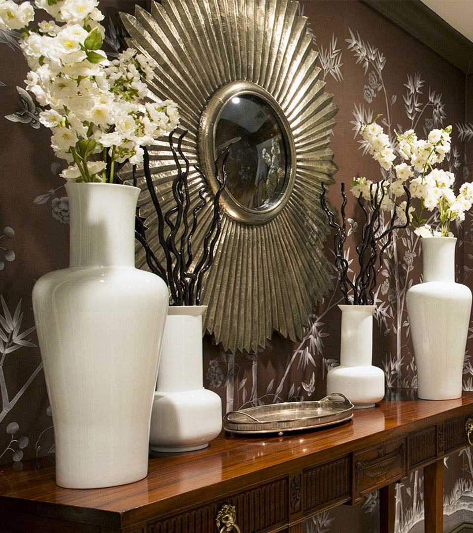 mandarin oriental entry with hall table and 2 white vases of flowers with sunburst mirror