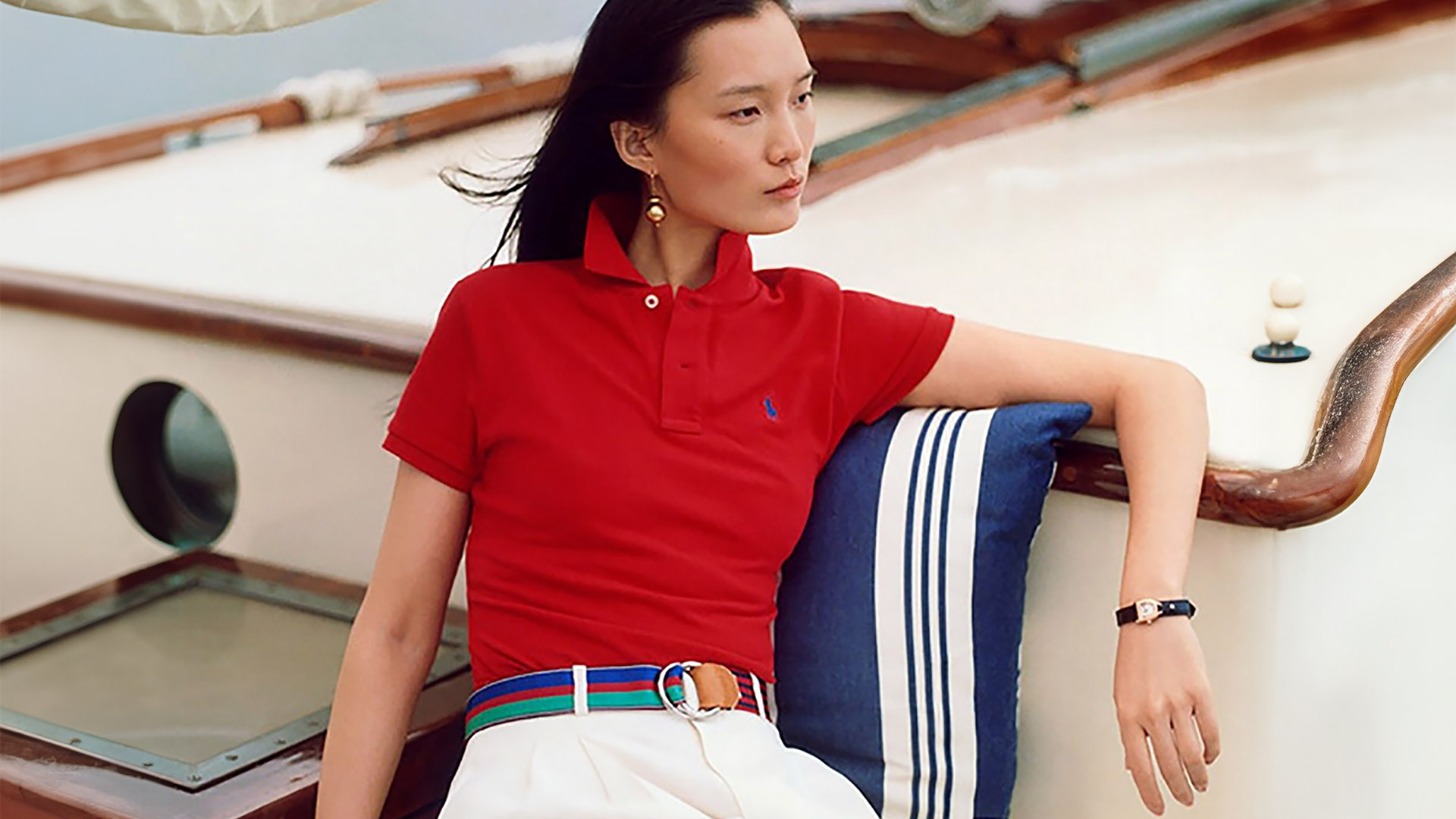 mirabelle bay asian woman on sailboat wearing red polo shirt and white pants horizontal