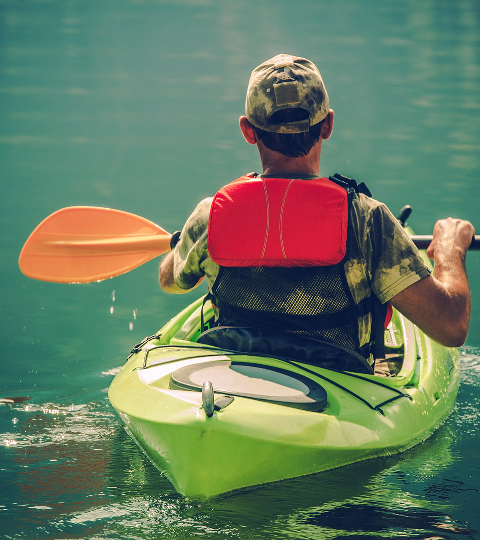 re150 man in green kayak and orange paddle