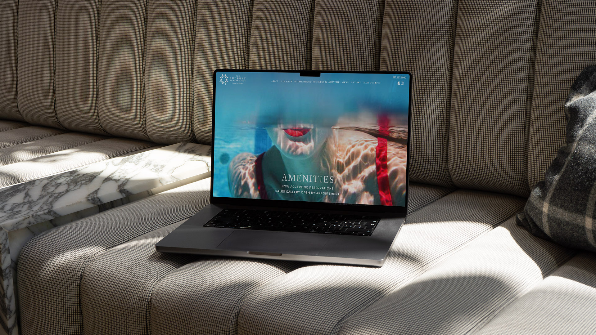 sudbury residences website with laptop on sofa