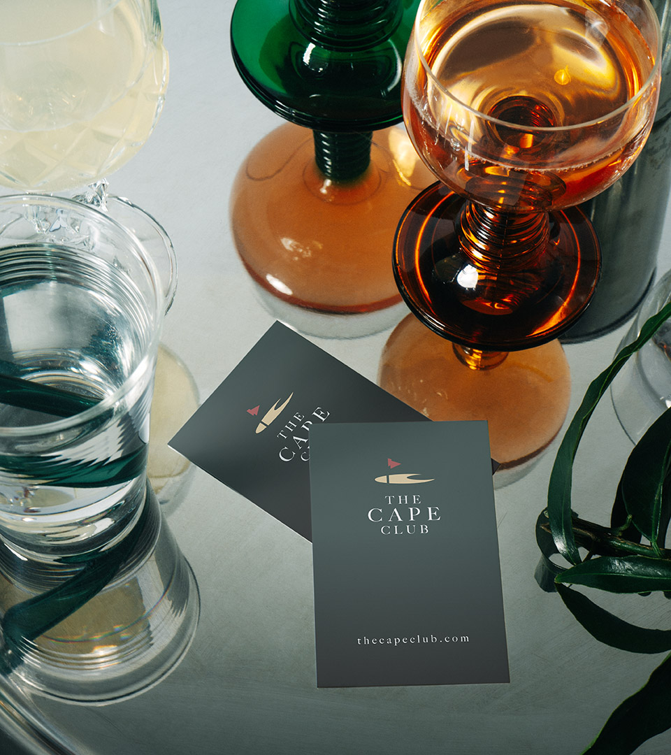 the cape club business cards on table